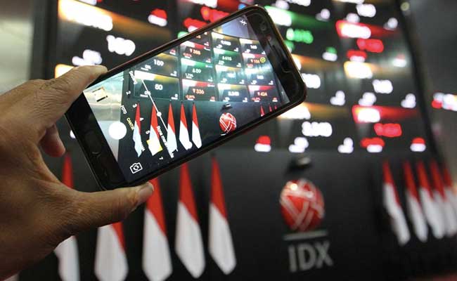 Pengunjung menggunakan ponsel memotret papan elektronik yang menampilkan pergerakan harga saham di Jakarta, Jumat (31/1/2020)./Bisnis-Dedi Gunawan  