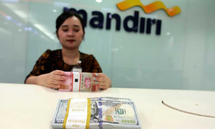 Petugas teller menata uang rupiah dan dolar AS di salah satu cabang Bank Mandiri di Jakarta, Rabu (19/2/2020). Bisnis/Arief Hermawan P