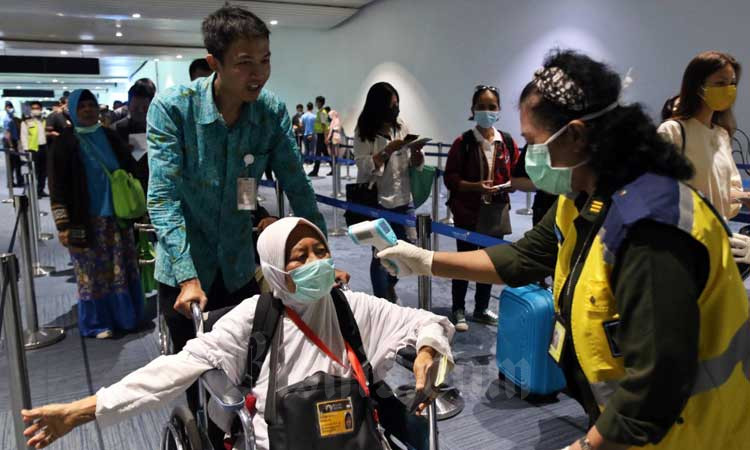 Petugas memeriksa suhu tubuh penumpang yang baru tiba di Terminal 3 Kedatangan Internasional Bandara Soekarno Hatta, Tangerang, Banten, Senin (2/3/2020).Bisnis/Eusebio Chrysnamurti