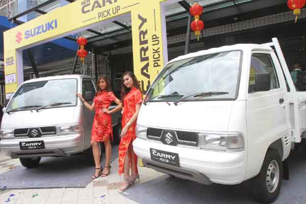 Model berdiri disamping mobil Suzuki New Carry Pick Up disela peluncurannya di Jakarta, Kamis (26/1). PT Suzuki Indomobil Sales , memperkenalkan produk terbarunya di segmen kendaraan niaga, New Carry Pick Up. Mobil ini dijual seharga Rp120,75 juta untuk varian flat deck dan Rp121,75 juta untuk varian wide deck. / Bisnis-Endang Muchtar