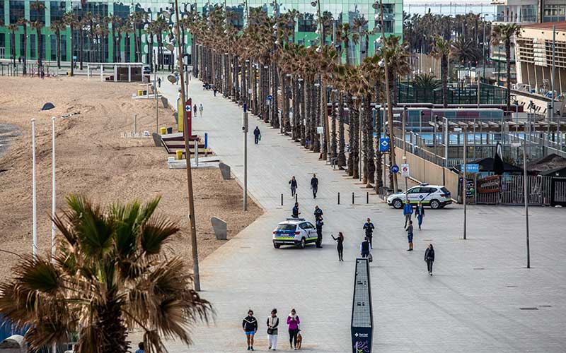 Polisi berpatroli di tepi pantai saat otoritas memberlakukan lockdown di kawasan pantai Barceloneta di Barcelona, Spanyol, Minggu (15/3/2020)./Bloomberg-Angel Garcia