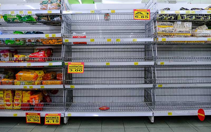 Sejumlah rak yang memajang produk mie instan kosong di sebuah supermarket di Shah Alam, Selangor, Malaysia, Selasa (17/3/2020). Setelah Perdana Menteri Muhyiddin Yassin mengumumkan Malaysia melakukan lockdown nasional, sejumlah supermarket diserbu masyarakat. Bloomberg/Samsul Said