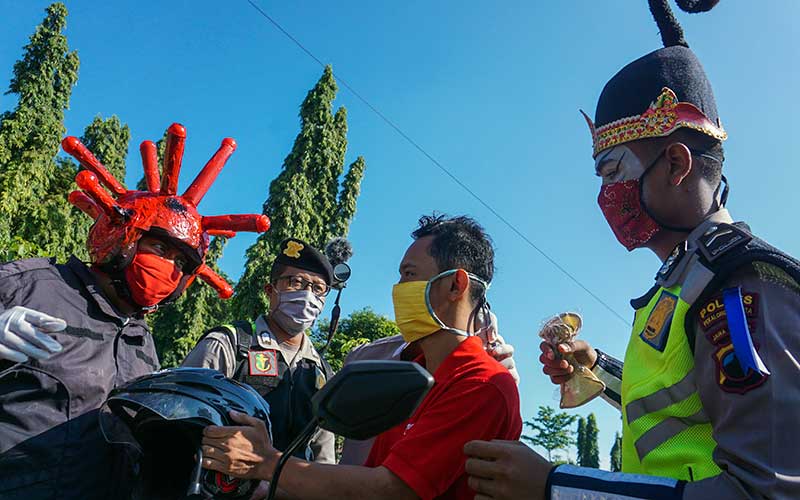  POLISI GUNAKAN KOSTUM PUNKAWAN SAAT BAGIKAN MASKER