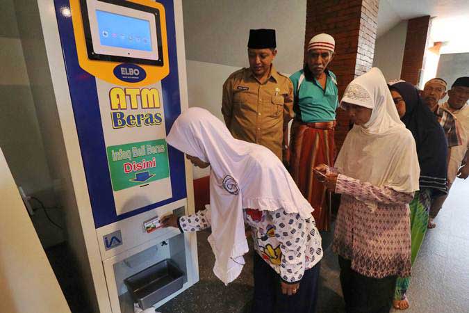 Warga antre menggunakan mesin Anjungan Tunai Mandiri (ATM) Beras di masjid Al Khalid di Kelurahan Semampir, Kota Kediri, Jawa Timur, Senin (18/3/2019)./ANTARA-Prasetia Fauzani