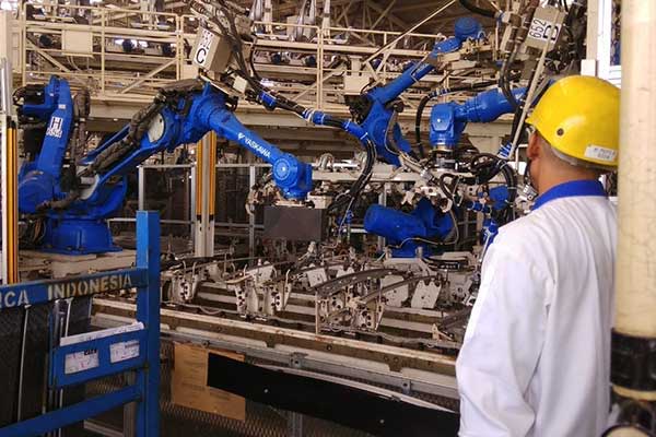 Seorang pekerja mengawasi proses pengelasan atau welding yang dilakukan oleh robot di pabrik perakitan Suzuki Cikarang, Jawa Barat, Selasa (19/2/2018) /Bisnis.com, Muhammad Khadafi