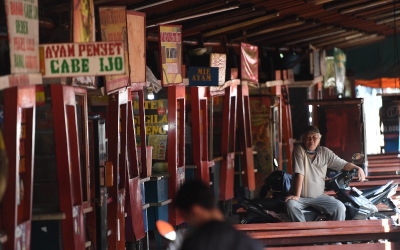 Seorang pria duduk di deretan warung kaki lima yang tutup menyusul sepinya pengunjung akibat pandemi COVID-19 di Jakarta, Kamis (2/4/2020). Minimnya aktivitas perkantoran di Jakarta akibat pandemi COVID-19 membuat sejumlah pedagang warung kaki lima memilih untuk menutup dagangannya dan mudik ke kampung halaman./ANTARA FOTO-Akbar Nugroho Gumay