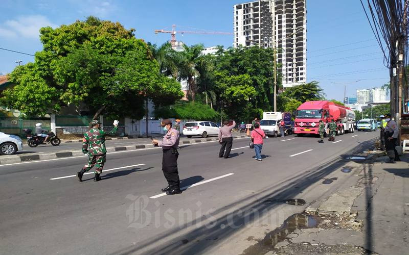 Petugas gabungan dari kepolisian, TNI dan Satpol PP memantau pengendara yang melintas di depan Kantor Polisi Polsek Metro Tanah Abang, JakartaPusat pada pelaksanaan hari kelima pembatasan sosial berskala besar (PSBB), Selasa (14/4/2020). JIBI/Bisnis-Andi M Arief