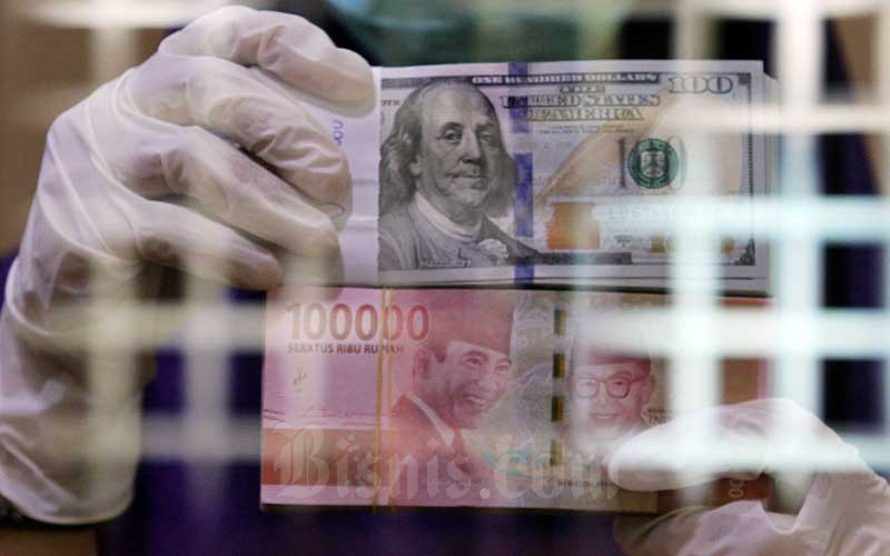 Karyawati menunjukan mata uang Rupiah dan Dollar Ameika Serikat di salah satu gerai penukaran mata uang asing di Jakarta, Kamis (2/4/2020). Bisnis/Arief Hermawan P