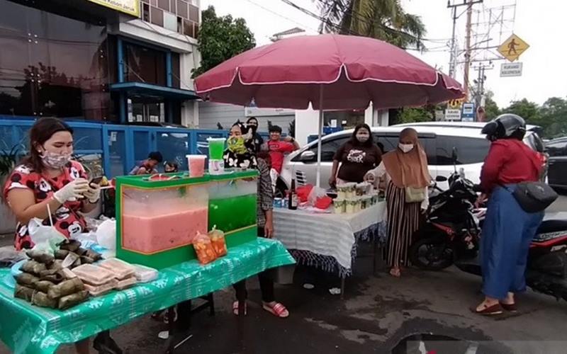 Pedagang takjil mengenakan masker dan sarung tangan saat berjualan di Jalan Panjang Kebon Jeruk, Jakarta Barat, Jumat (24/4/2020)./Antarann