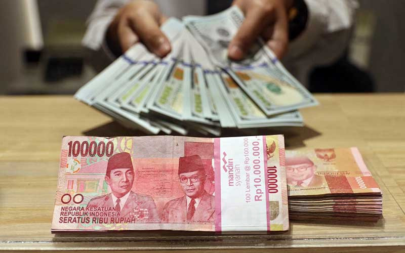 Karyawan menunjukan uang dolar Amerika Serikat (AS) di Jakarta, Senin (18/5/2020). Bisnis/Eusebio Chrysnamurti