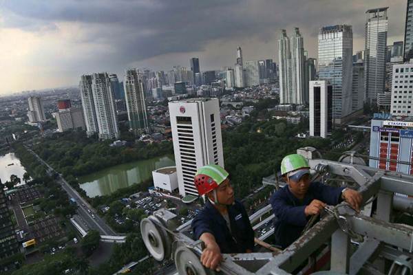 Pekerja melakukan perawatan rutin pada salah satu gedung bertingkat di Jakarta, Rabu (22/11)./JIBI-Nurul Hidayat