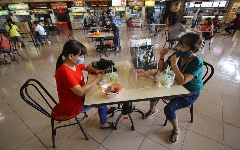 Pengunjung menikmati makanan di meja makan yang bersekat di pusat jajanan serba ada (pujasera) atau food court Pasar Atom, Surabaya, Jawa Timur, Selasa (9/6/2020)./Antara-Moch Asim
