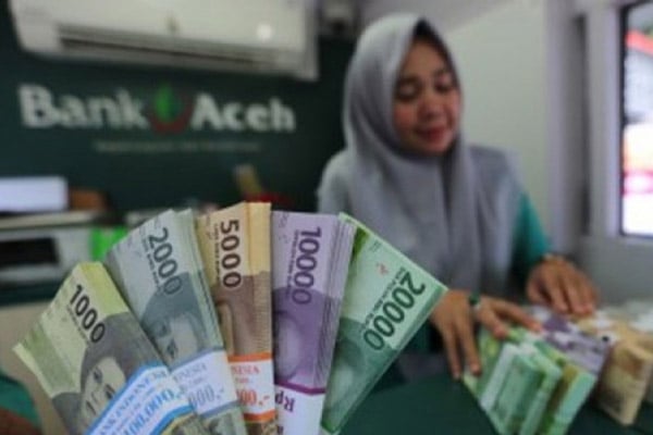 Seorang karyawati menghitung uang di salah satu kantor cabang Bank Aceh./Antara-Irwansyah Putra