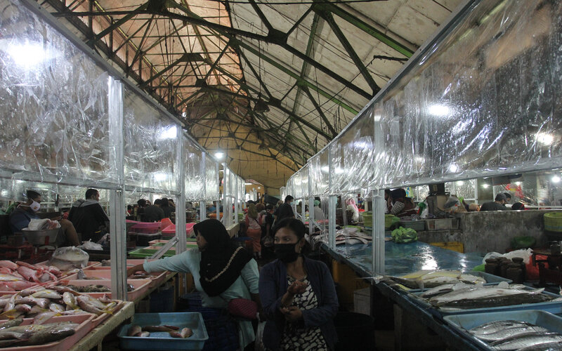 Warga beraktivitas di Pasar Ikan Pabean Surabaya, Jawa Timur, Senin (22/6/2020). Pasar tersebut menerapkan protokol pencegahan penularan Covid-19 seperti penyekat plastik di lapak pedagang, cuci tangan, jaga jarak dan kewajiban memakai masker bagi warga yang beraktivitas di pasar itu untuk memutus penularan Covid-19./Antara-Didik Suhartono