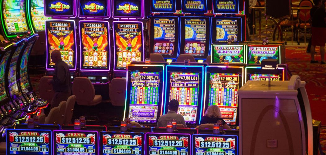 Para pemain menggunakan mesin judi di kasino Encore Boston Harbor, yang dikelola oleh Wynn Resorts Ltd., di Everett, Massachusetts, AS, Minggu (23/6/2019). - Bloomberg/Scott Eisen