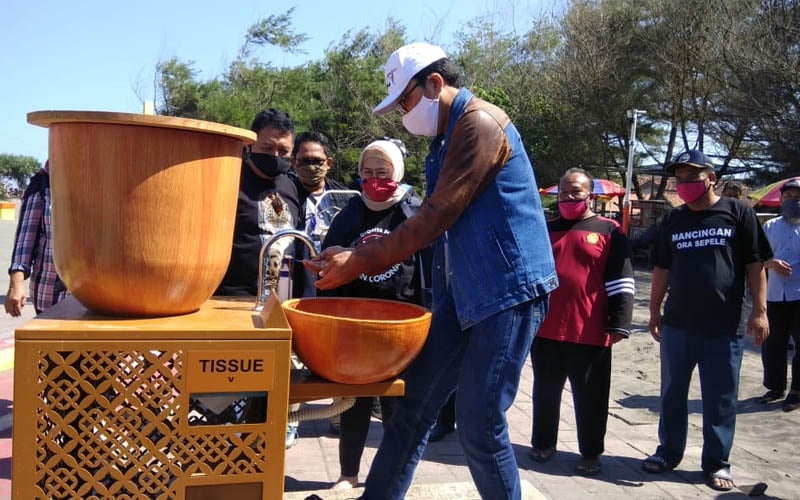 Kepala Dinas Pariwisata DIY, Singgih Raharjo mencoba tempat cuci tangan yang disediakan di kawasan Pantai Parangtritis, Sabtu (13/6/2020). /JIBI-Ujang Hasanudin