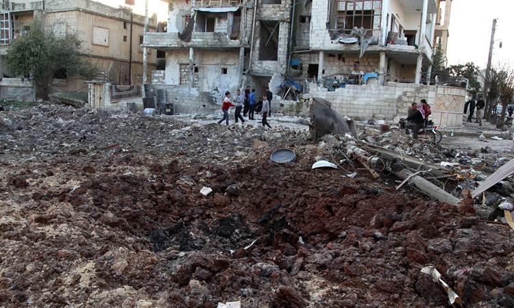 Warga Suriah berada di dekat puing bangunan setelah terjadi serangan udara di Maarrat Misrin, Idlib 25 Februari 2020/Bloomberg-Abdulaziz Ketaz/AFP via Getty Images