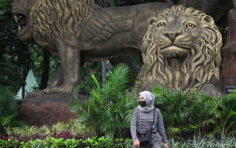 Pejalan kaki melintas di depan patung Tiga Singa saat Pembatasan Sosial Berskala Besar (PSBB) di Taman Trunojoyo, Malang, Jawa Timur, Kamis (28/5/2020)./Antara-Ari Bowo Sucipto