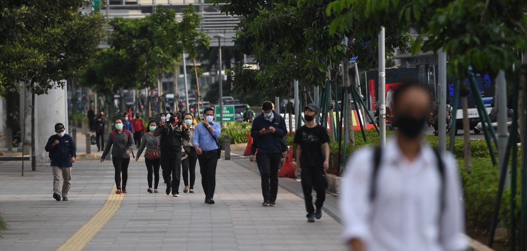 Sejumlah pekerja berjalan usai bekerja dengan latar belakang gedung perkantoran di Jl. Jenderal Sudirman, Jakarta, Kamis (16/4/2020). - ANTARA FOTO/Akbar Nugroho Gumay