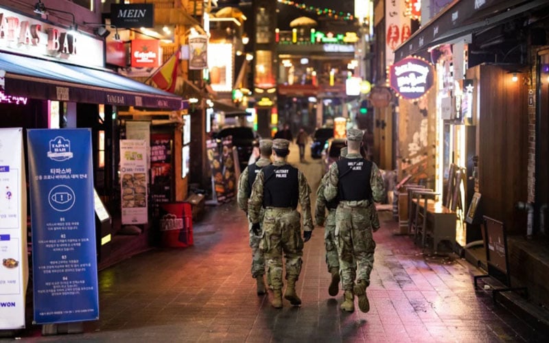 Polisi militer Angkatan Darat AS berpatroli di jalan di Itaewon, Seoul, Korea Selatan, pada Sabtu (9/5/2020) malam, ketika gelombang kedua infeksi virus corona berpotensi muncul, terkait dengan aktivitas kelab malam malam./Bloomberg