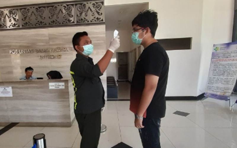 Ilustrasi-Seorang petugas Kantor Kesehatan Pelabuhan (KKP) Entikong mengukur suhu tubuh pelintas batas yang hendak ke Malaysia di Pos Lintas Batas Negara (PLBN) Entikong di Kabupaten Sanggau, Kalimantan Barat, Jumat (13/3/2020)./ANTARA-AGUS ALFIAN
