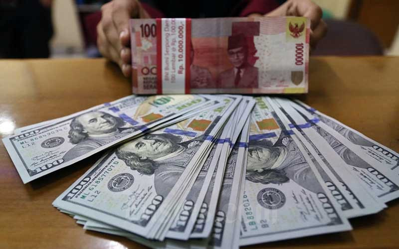 Karyawan menunjukan uang dolar Amerika Serikat (AS) dan Rupiah di salah satu gerai penukaran mata uang asing di Jakarta, Rabu (22/7/2020). Bisnis/Eusebio Chrysnamurti 