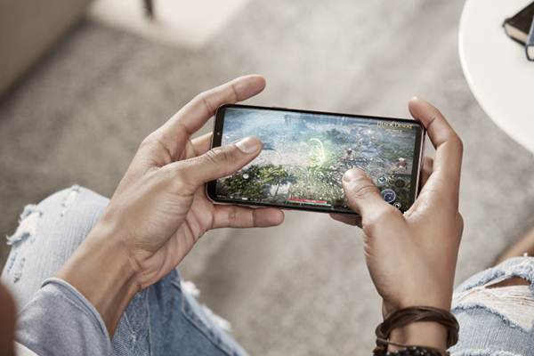 Seseorang yang candu permainan game melalui smartphone dan bisa menghabiskan waktu berjam-jam/Ilustrasi pemain gim mobile/Samsung.com