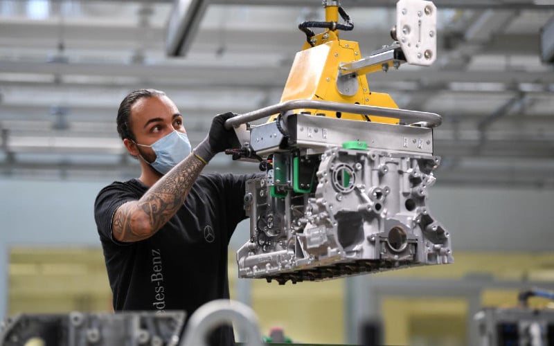 Seorang pekerja merakit mesin untuk model Mercedes-Benz S di pabrik Mesin Daimler di Bad Cannstatt, ketika penyebaran virus corona (Covid-19) berlanjut di dekat Stuttgart, Jerman, 22 April 2020. - REUTERS