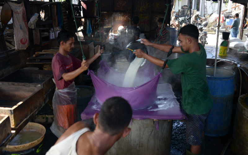 Perajin menuangkan cairan kacang kedelai saat proses produksi tahu di salah satu usaha pabrik di Banda Aceh, Aceh, Kamis (1/10/2020). /ANTARA FOTO