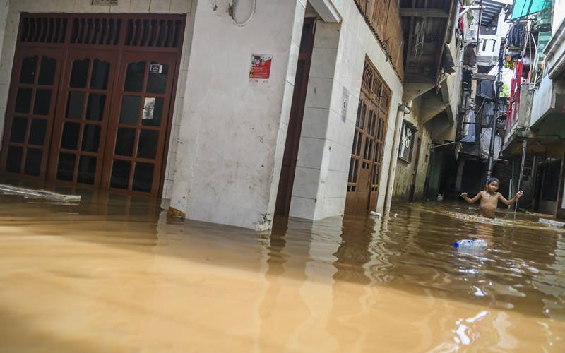 Warga berjalan melintasi banjir di Kebon Pala, Jatinegara, Selasa (22/9/2020). Banjir tersebut terjadi karena luapan Sungai Ciliwung. ANTARA FOTO/Galih Pradipta./Antara