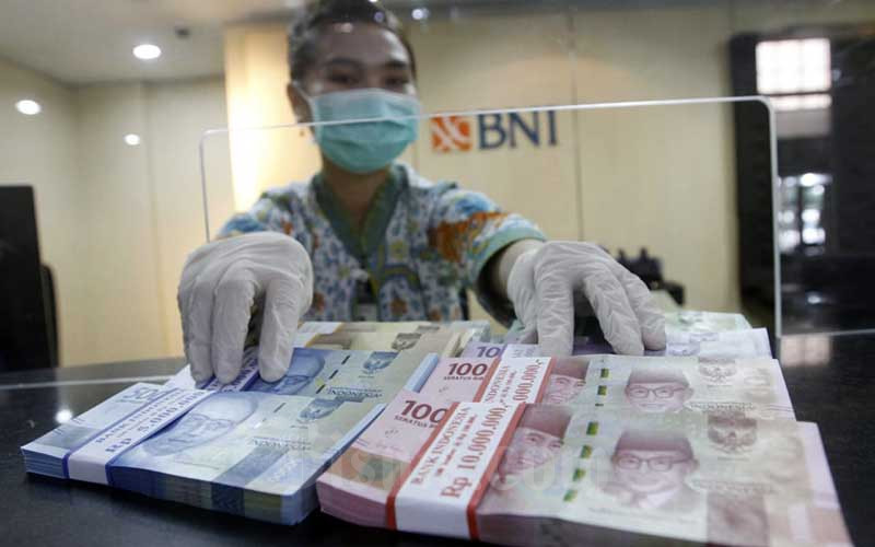 Karyawati menunjukan Uang Rupiah dan Dollar AS di salah satu kantor cabang Bank BNI di Jakarta, Kamis (3/9/2020).  Bisnis/Himawan L Nugraha