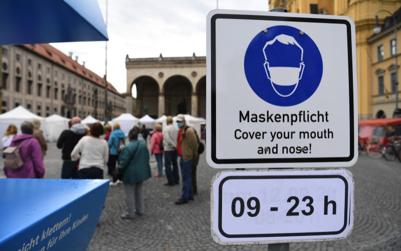Papan aturan penggunaan masker di ruang publik di Jerman./Bloomberg