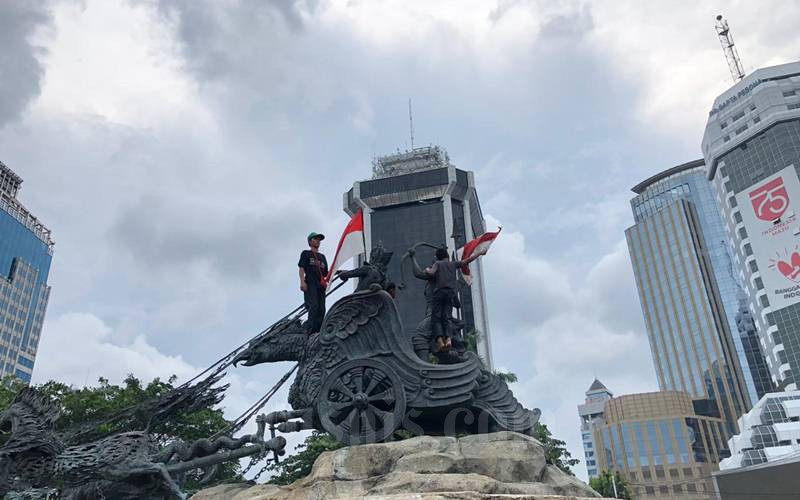  Demo Tolak UU Cipta Kerja: Heboh, Dua Remaja Panjat Patung Kuda dan Pasang Bendera Merah Putih