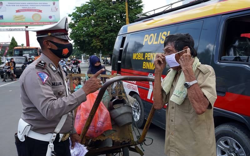 Petugas Satuan Lalu Lintas Polres Sorong Kota (kiri) mengingatkan pentingnya penggunaan masker kepada warga di Kota Sorong, Papua Barat, Kamis (10/9/2020)./Antara-Olha Mulalinda