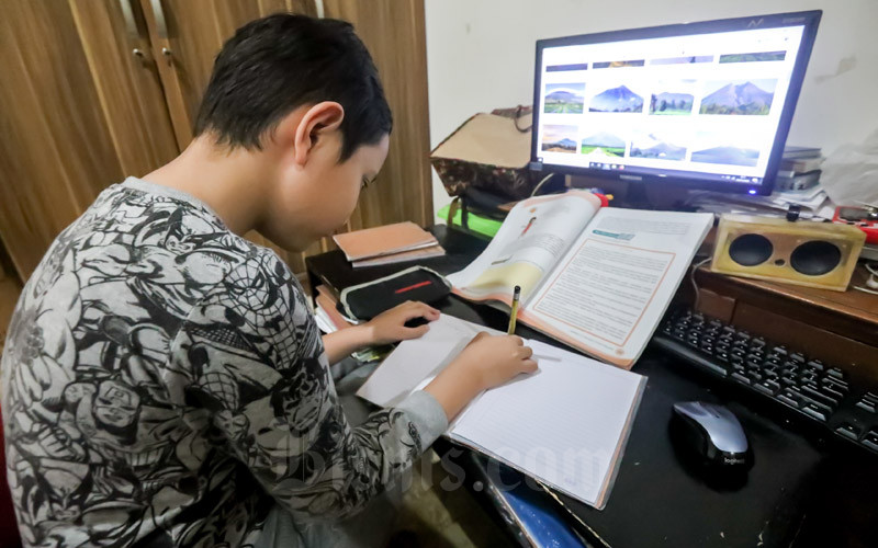 Seorang siwa tengah mengerjakan tugas sekolah secara daring/Bisnis-Dea Andriyawan