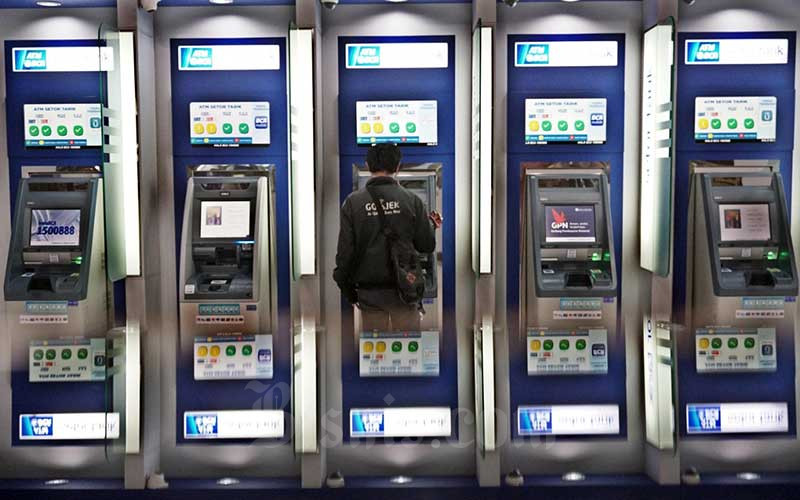 Nasabah melakukan transaksi lewat mesin anjungan tunai mandiri (ATM) di Tangerang Selatan, Banten, Sabtu (28/3/2020). Bisnis/Eusebio Chrysnamurti