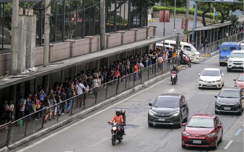 Penumpang mengantri untuk naik kereta Mass Rapid Transit (MRT) menjelang jam malam yang diberlakukan karena corona virus di Mandaluyong City, Metro Manila, Filipina, Senin (16/3/2020). Bloomberg/Veejay Villafranca 