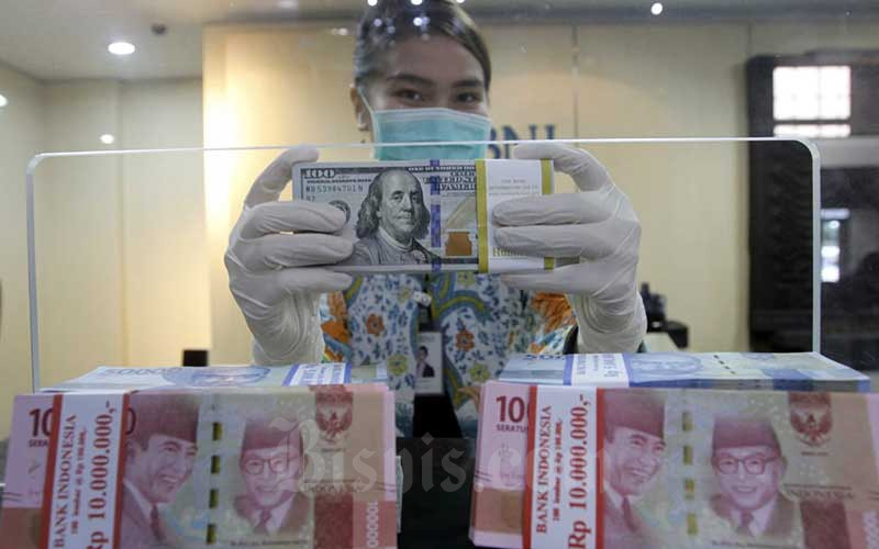 Karyawati menunjukan Uang Rupiah dan Dollar AS di salah satu kantor cabang Bank BNI di Jakarta, Kamis (3/9/2020).  Bisnis/Himawan L Nugraha