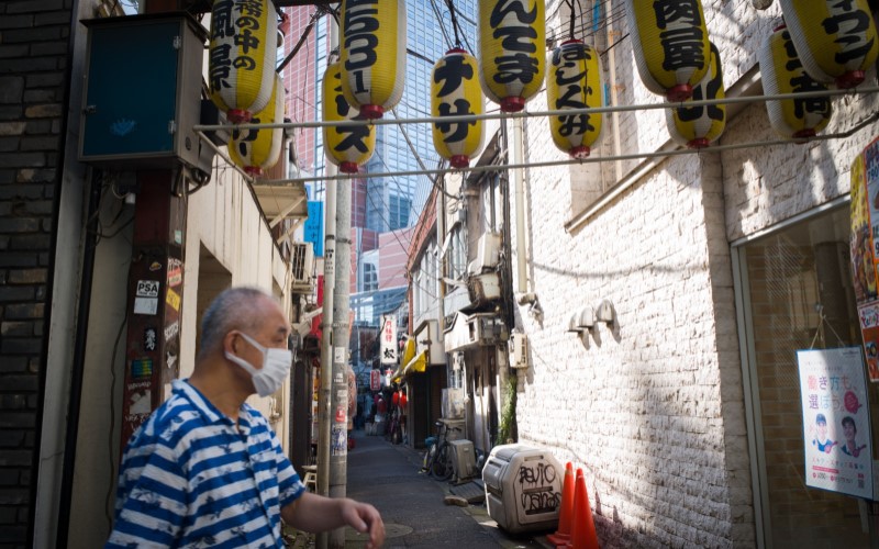 Ilustrasi - Seorang warga Jepang berdiri di sudut jalan di kota Tokyo./Bloomberg