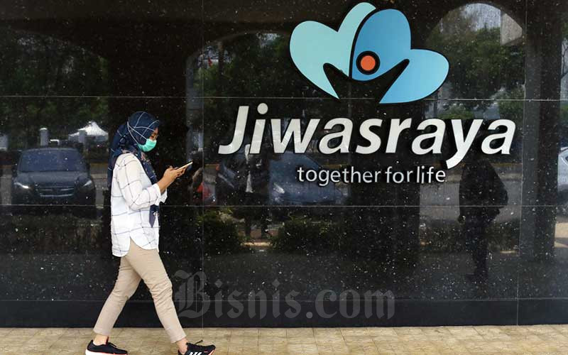 Warga melintasi logo Asuransi Jiwasraya di Jakarta, Senin (5/10/2020). Bisnis/Eusebio Chrysnamurti