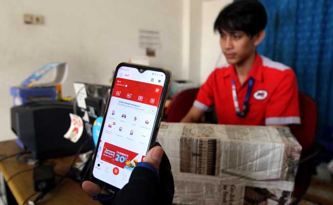 Pelanggan menggunakan aplikasi LinkAja di salah satu outlet JNE di Jakarta, Senin (10/2/2020). Bisnis/Arief Hermawan P