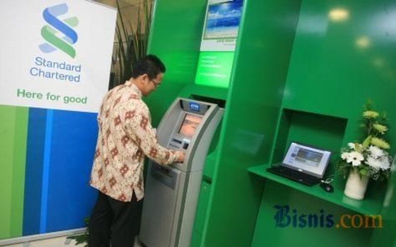 Nasabah melakukan transaksi di salah satu mesin ATM Standard Chartered Bank./JIBI
