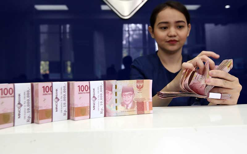 Karyawan menghitung uang pecahan Rp.100.000 di salah satu Bank yang ada di Jakarta, Senin (4/6). Bisnis/Abdullah Azzam