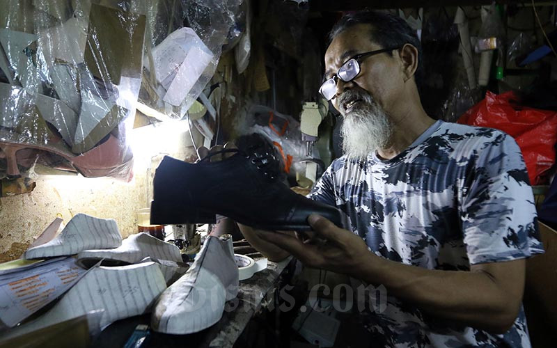 Pengrajin menyelesaikan pembuatan alas sepatu di Jakarta, Jumat (17/1/2020)./Bisnis-Abdullah Azzam