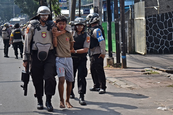 Sejumlah polisi mengamankan salah seorang warga yang diduga ikut aksi kerusuhan di Jalan KS. Tubun, Petamburan, Jakarta Pusat, Rabu (22/5/2019)/ANTARA FOTO-Aditya Pradana Putra