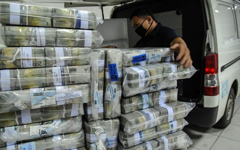 Petugas memasukan uang pecahan rupiah ke dalam mobil untuk didistribusikan dari Cash Center Mandiri, Jakarta, Senin (11/5/2020)./Antara Foto-Muhammad Adimaja