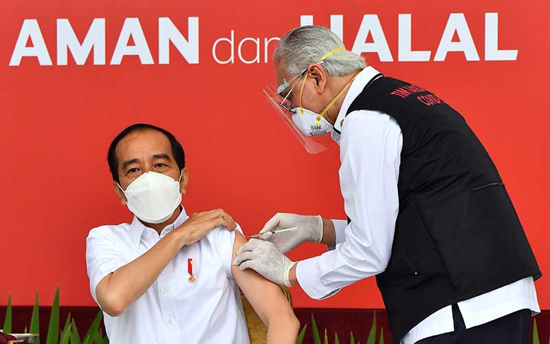 Presiden Joko Widodo bersiap disuntik dosis pertama vaksin Covid-19 produksi Sinovac oleh vaksinator Wakil Ketua Dokter Kepresidenan Abdul Mutalib (kanan) di beranda Istana Merdeka, Jakarta, Rabu (13/1/2021). Penyuntikan perdana vaksin Covid-19 ke Presiden Joko Widodo tersebut menandai dimulainya program vaksinasi di Indonesia. ANTARA FOTO/HO/Setpres-Agus Suparto