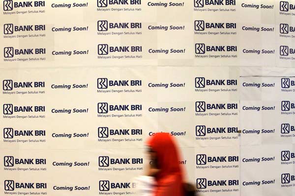 Pengunjung melintasi logo Bank BRI di sebuah pusat perbelanjaan di Jakarta, Senin (13/4)./Bisnis.com