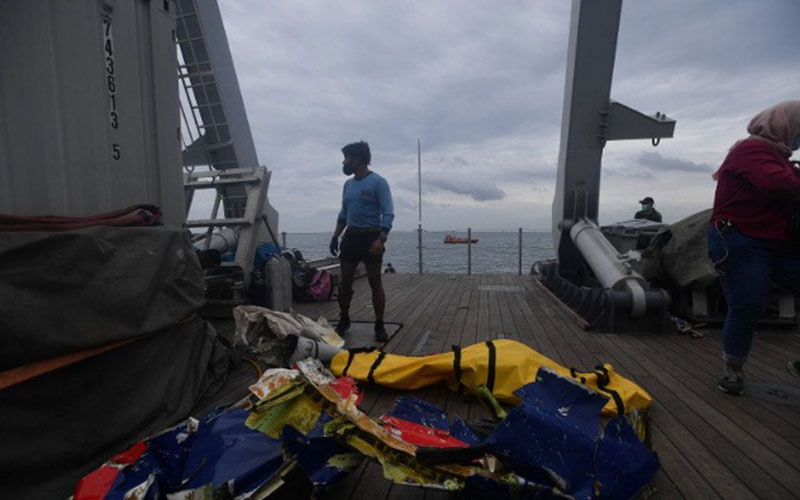 Prajurit Kopaska TNI AL berdiri di dekat kantong berisi jenazah dan serpihan dari pesawat Sriwijaya Air SJ182 yang dievakuasi ke atas KRI Rigel-933 di perairan Kepulauan Seribu, Jakarta, Minggu (10/1/2021)./Antara/Sigid Kurniawan