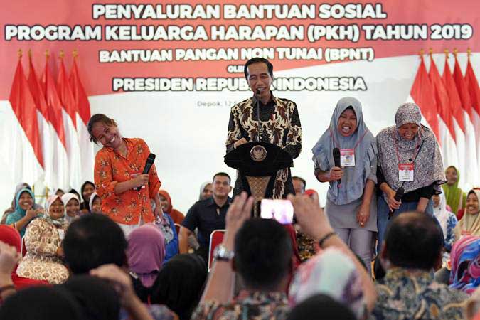 Presiden Joko Widodo (kedua kiri) berbincang dengan penerima Bantuan Sosial Program Keluarga Harapan (PKH) Tahun 2019 di Sukmajaya, Depok, Jawa Barat, Selasa (12/2/2019). - ANTARA FOTO/Puspa Perwitasari